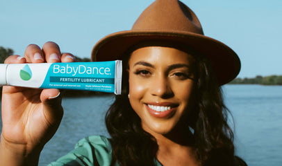 woman holding up a tube of BabyDance fertility lubricant