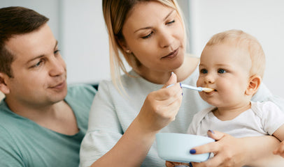 mom and dad feeding baby