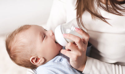 mother feeding baby with milk bottle