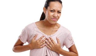 woman wincing and holding breast due to pain