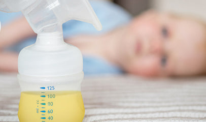 baby looking at bottle of colostrum