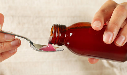 woman pouring cough syrup on spoon for fertility use