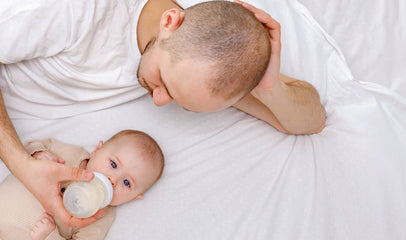 dad feeding baby with bottle