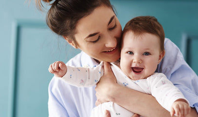 happy mother holding baby before breastfeeding