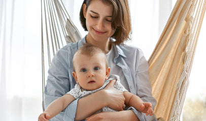 mom and baby sitting on hammock