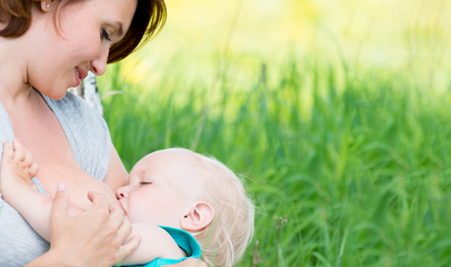 mom breastfeeding baby outside in nature