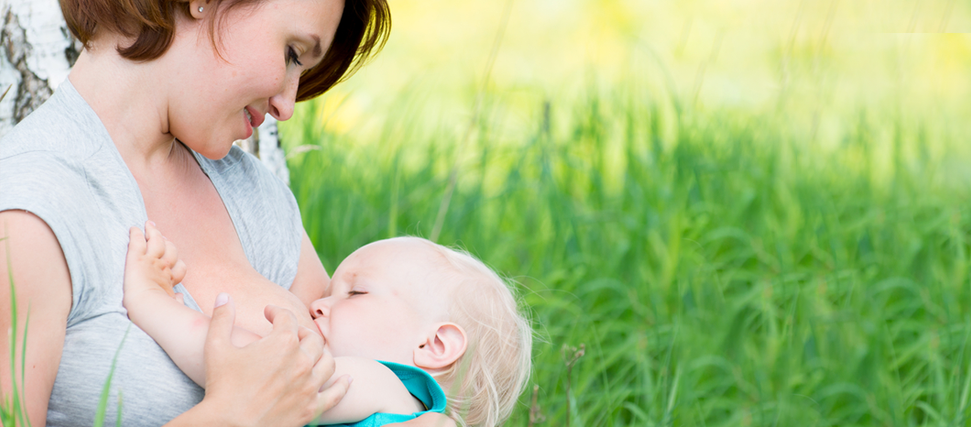 mom breastfeeding baby outside in nature