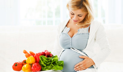 pregnant woman next to vegetables for immunity support