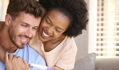 happy couple looking at results of pregnancy test