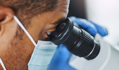 man looking at proteins under microscope