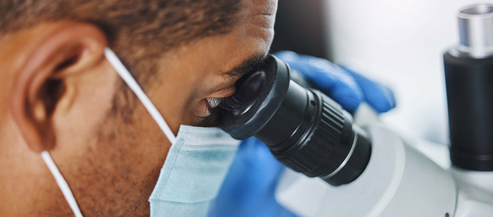 man looking at proteins under microscope