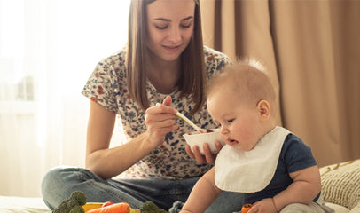 mother feeding baby solid foods