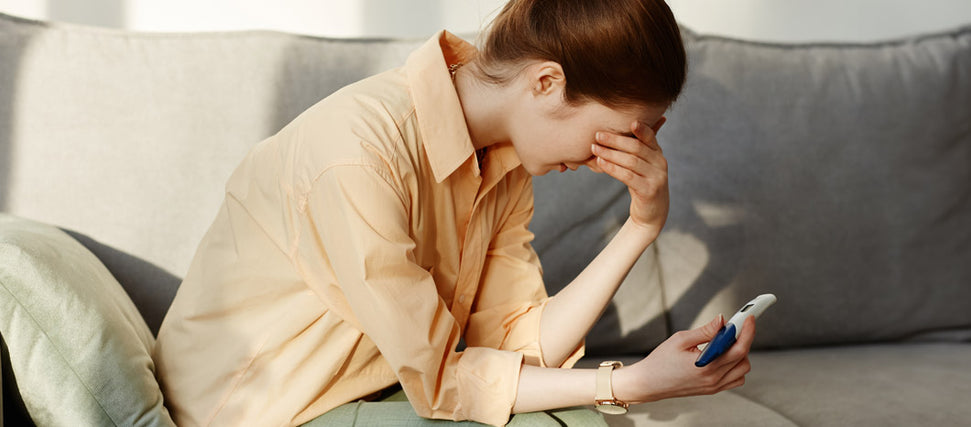 stressed woman looking at pregnancy test