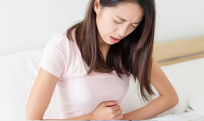 woman holding stomach due to menstrual cramps