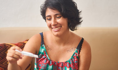 woman smiling holding ovulation test